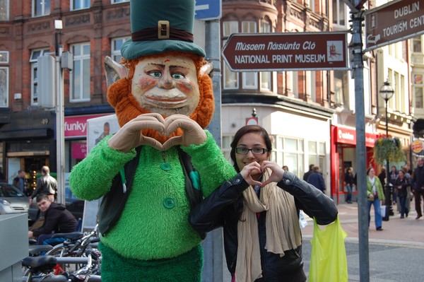 A student poses with a Irish statue while on an educational tour