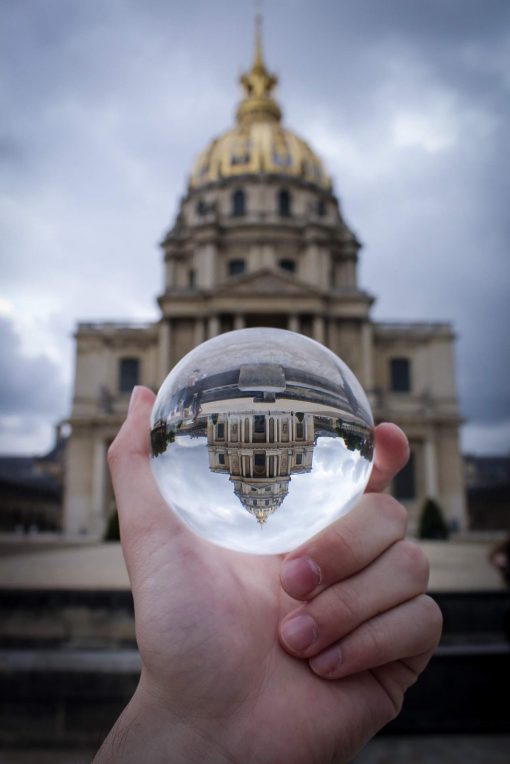 2019 Scenic Photo winner, a glass orb held up in front of a golden cathedral shows an upside down reflection of the building