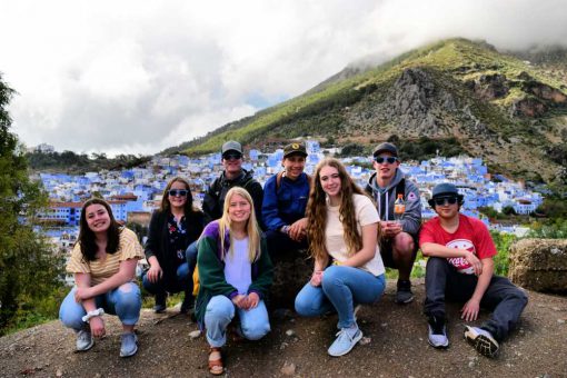 2019 Group Photo Winner, a group of student pose above the blue city of Chefchaouen, Morocco